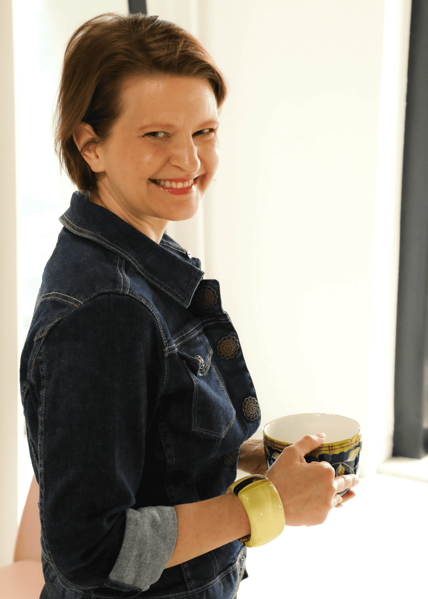 Heather smiling holding coffee cup